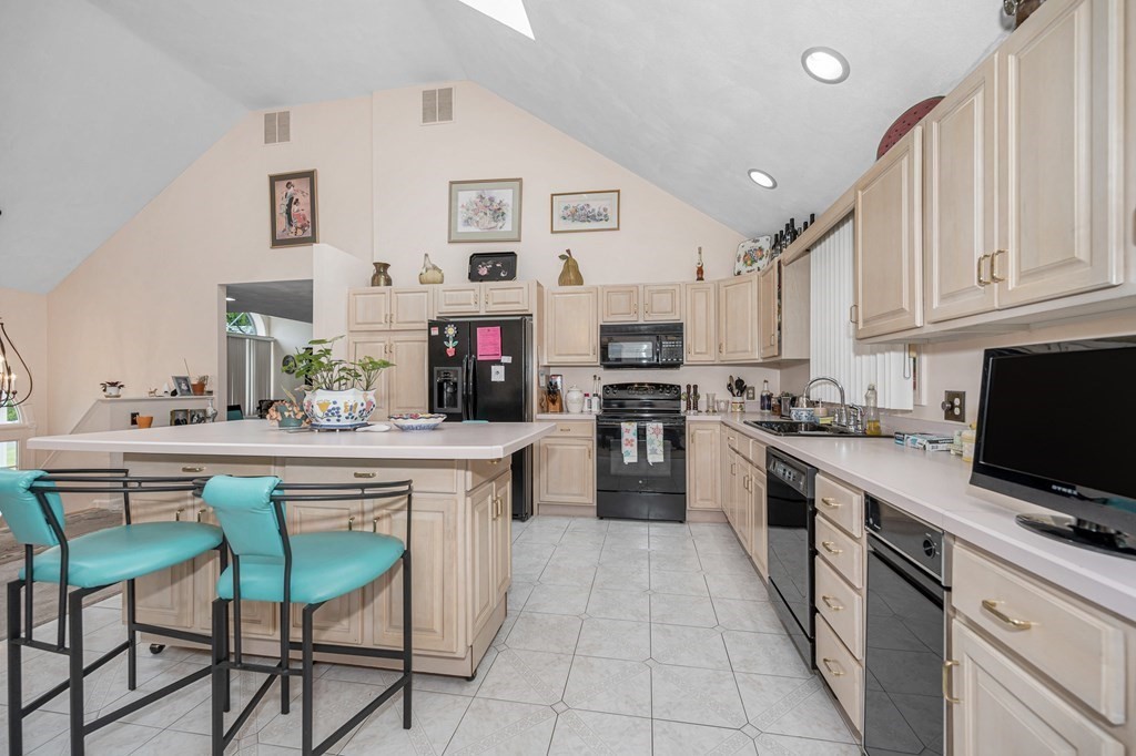 49 Susan Drive Saugus, MA 01906 - Photo 9 of 33 a kitchen with kitchen island granite countertop a sink counter space stainless steel appliances and cabinets
