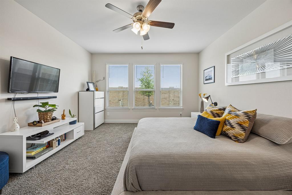 425 Breeds Hl Road Little Elm, TX 75068 - Photo 12 of 38 a spacious bedroom with a bed and a flat screen tv
