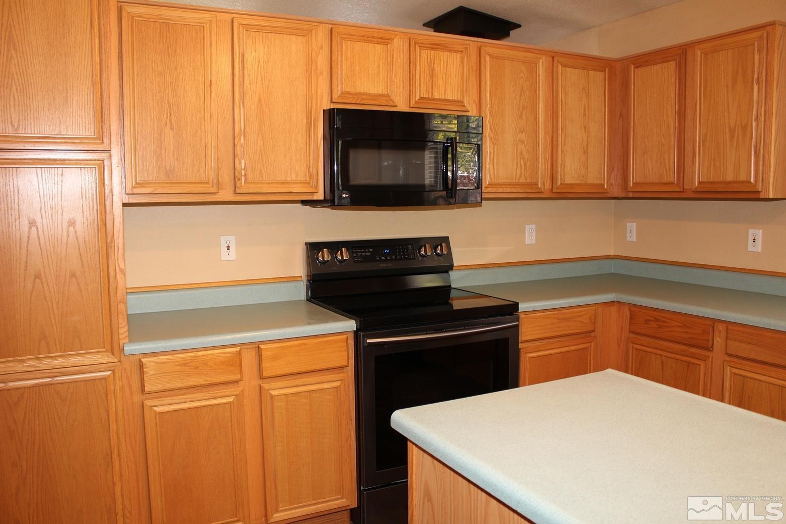 100 Calistoga Court Reno, NV 89508 - Photo 11 of 40 a kitchen with granite countertop white cabinets and black appliances