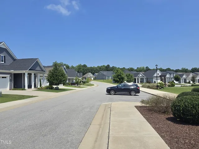 a view of a street with a house in the background