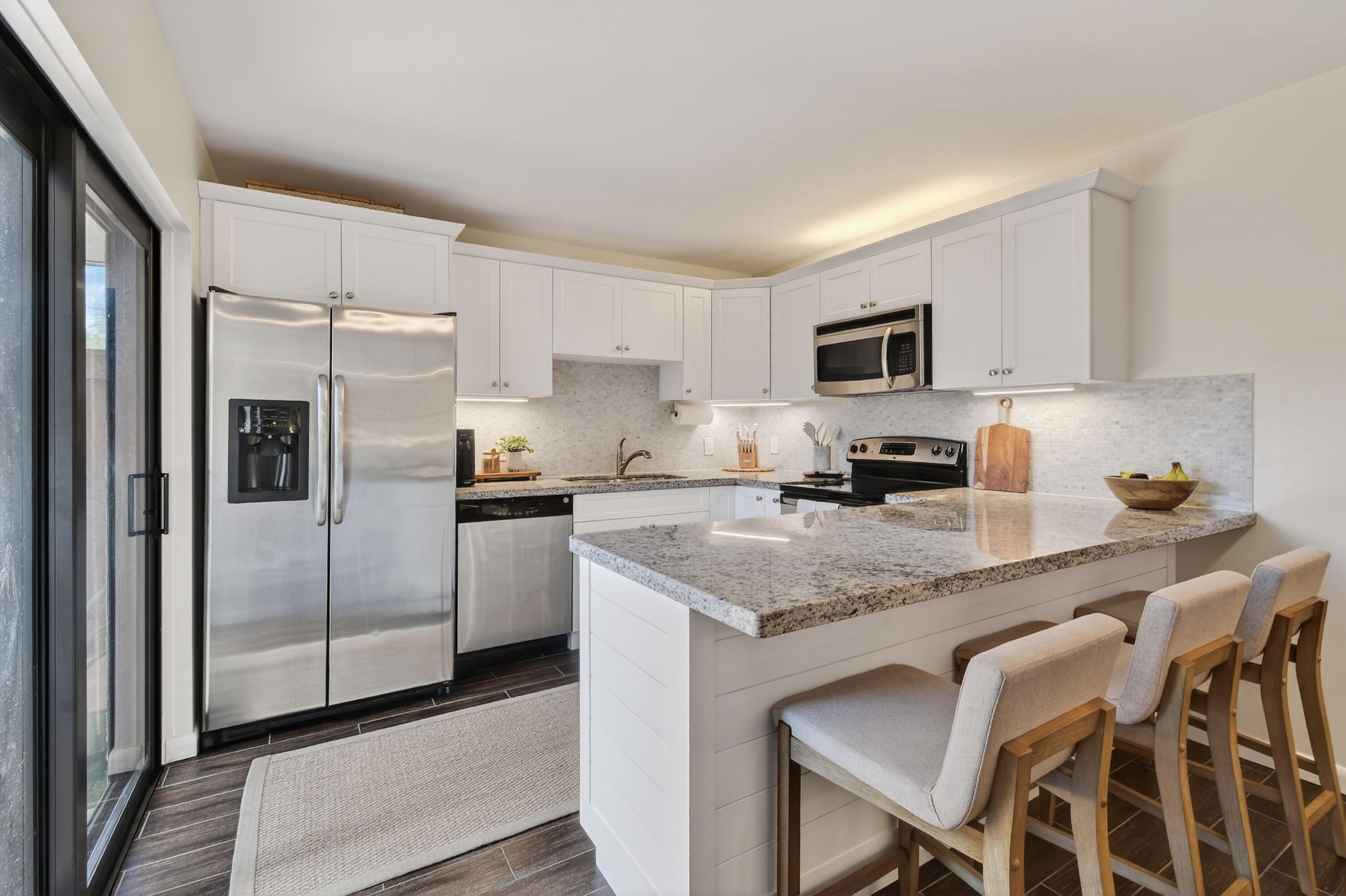 3900 County Line Road, Unit 15A Tequesta, FL 33469 - Photo 11 of 37 a kitchen with granite countertop a refrigerator stove microwave and sink