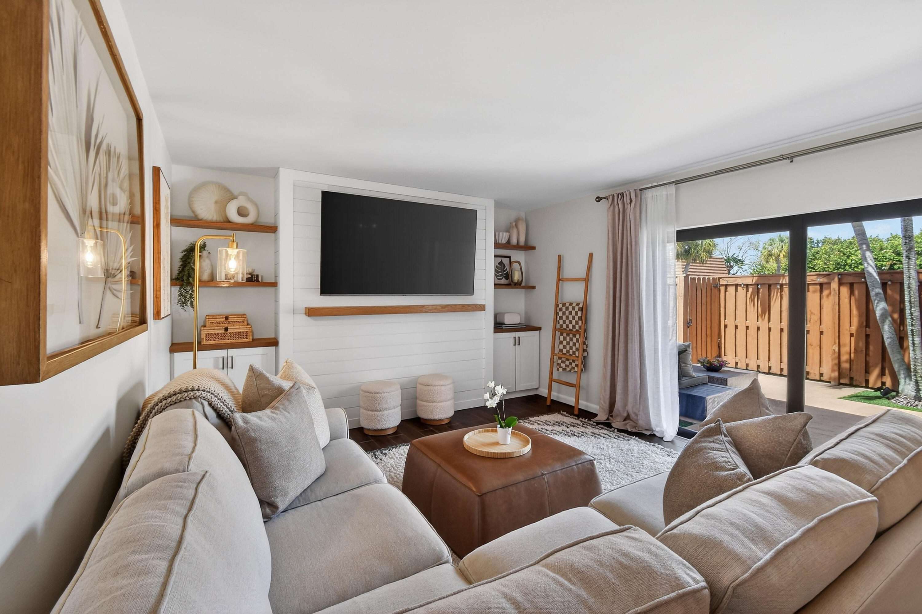 3900 County Line Road, Unit 15A Tequesta, FL 33469 - Photo 4 of 37 a living room with furniture a flat screen tv and a floor to ceiling window