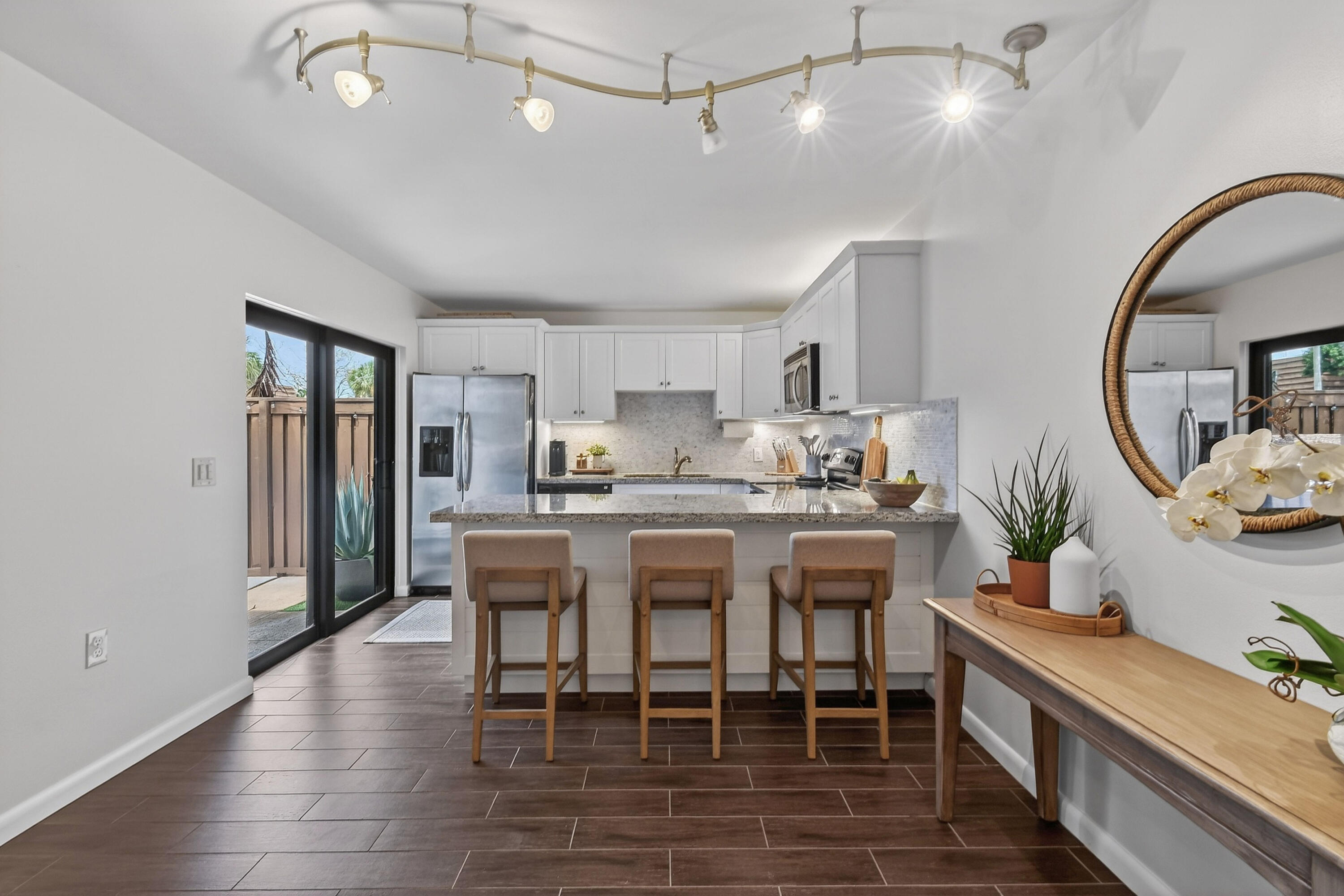 3900 County Line Road, Unit 15A Tequesta, FL 33469 - Photo 10 of 37 a kitchen with kitchen island a dining table chairs stainless steel appliances and cabinets