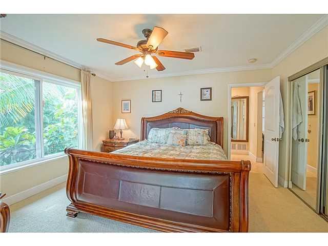 1041 Southeast Riverside Drive Stuart, FL 34996 - Photo 13 of 25 a bedroom with a large bed and a chandelier