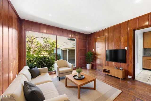a living room with furniture a flat screen tv and a large window