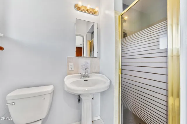 a bathroom with a sink a toilet and mirror