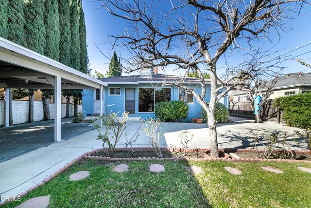 a patio with a table and chairs and plants