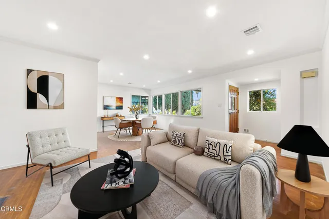 a living room with furniture a rug a lamp and a window