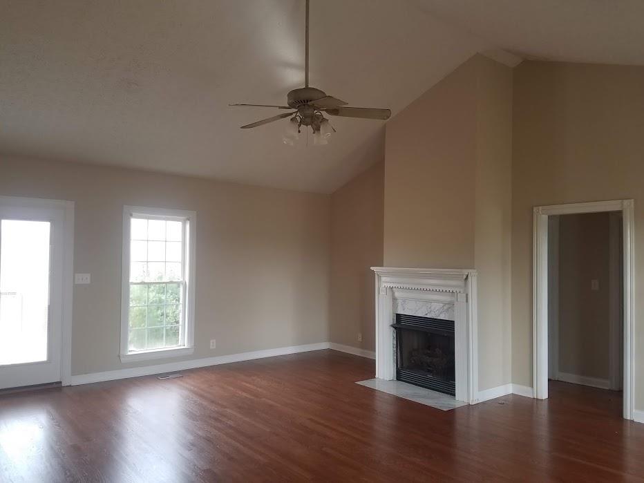 4686 Matthews Road Cedar Hill, TN 37032 - Photo 3 of 20 an empty room with wooden floor a fireplace and windows