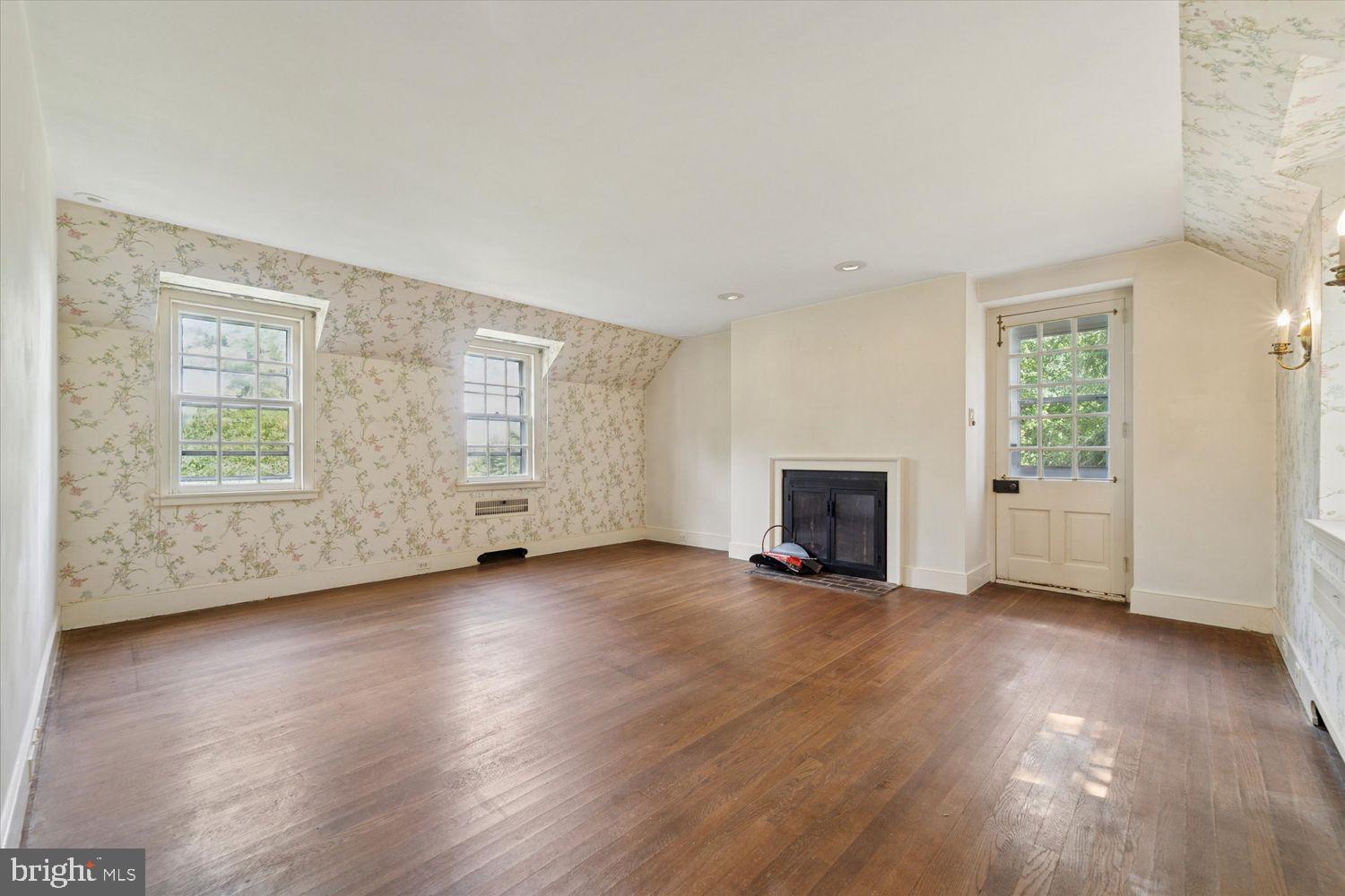 409 Marple Road Broomall, PA 19008 - Photo 25 of 37 an empty room with wooden floor fireplace and windows