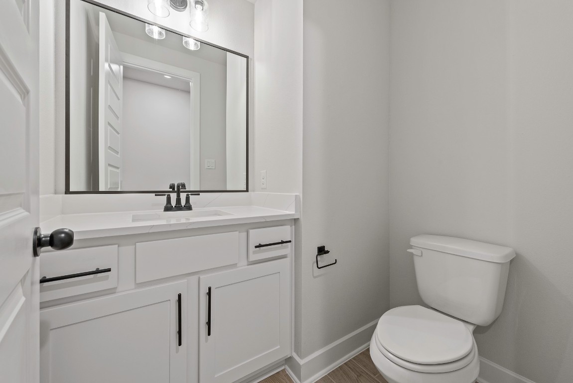 213 Buckaroo Drive Georgetown, TX 78633 - Photo 13 of 22 a bathroom with a toilet a sink a mirror and vanity