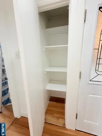 a view of a hallway with wooden floor and entryway