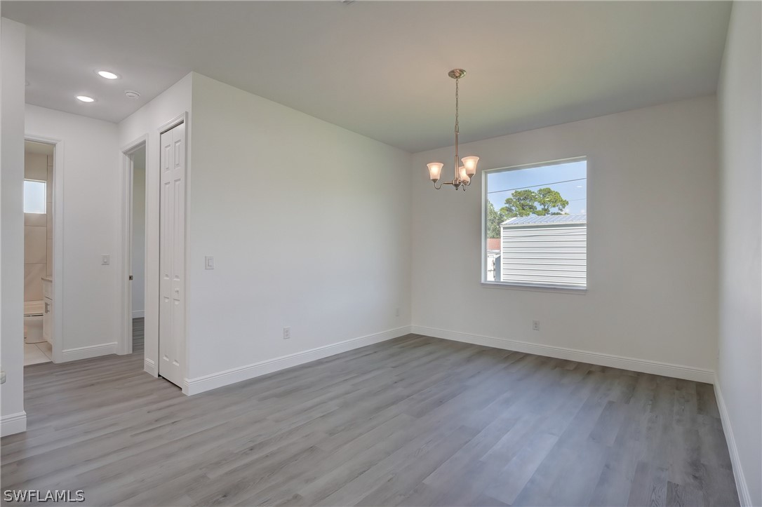 18457 Lee Road Fort Myers, FL 33967 - Photo 11 of 28 a view of an empty room with wooden floor and a window
