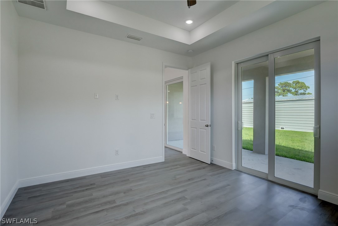 18457 Lee Road Fort Myers, FL 33967 - Photo 13 of 28 a view of an empty room with wooden floor and a window