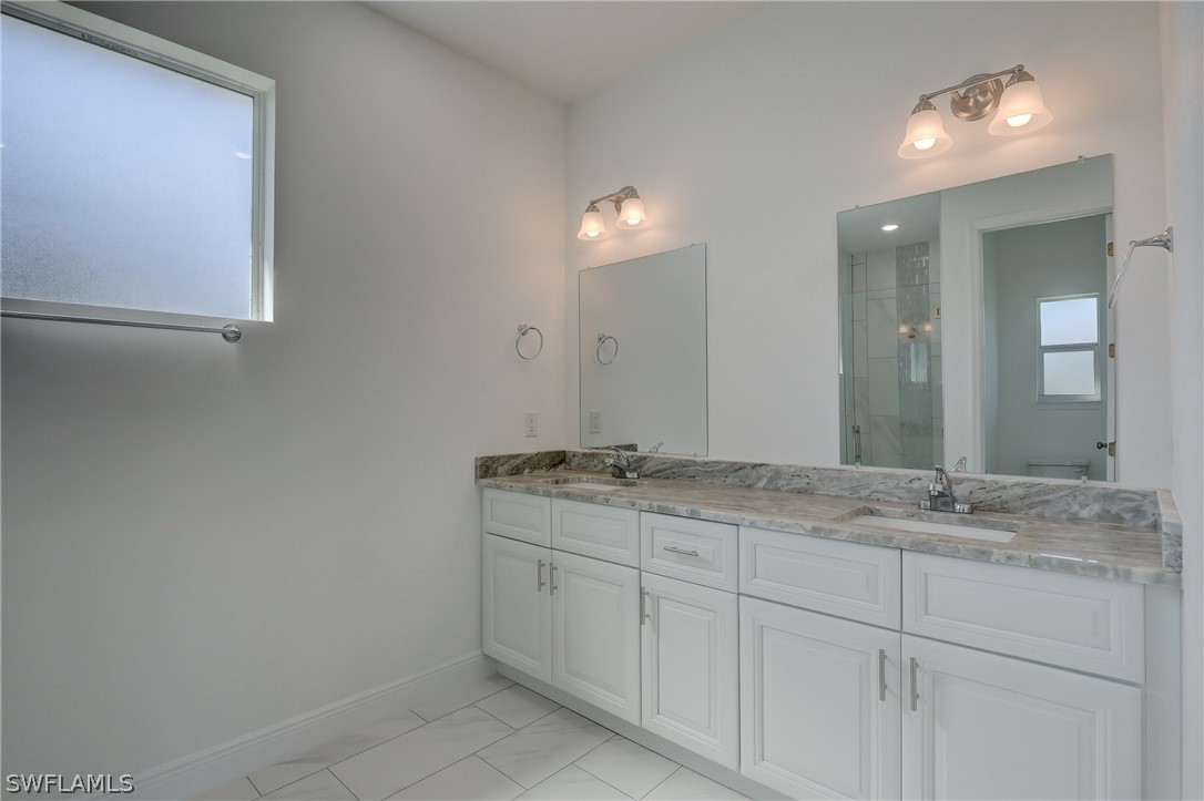 18457 Lee Road Fort Myers, FL 33967 - Photo 15 of 28 a bathroom with a granite countertop sink and a mirror