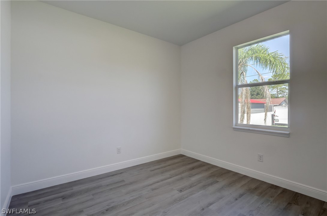 18457 Lee Road Fort Myers, FL 33967 - Photo 18 of 28 an empty room with wooden floor and windows