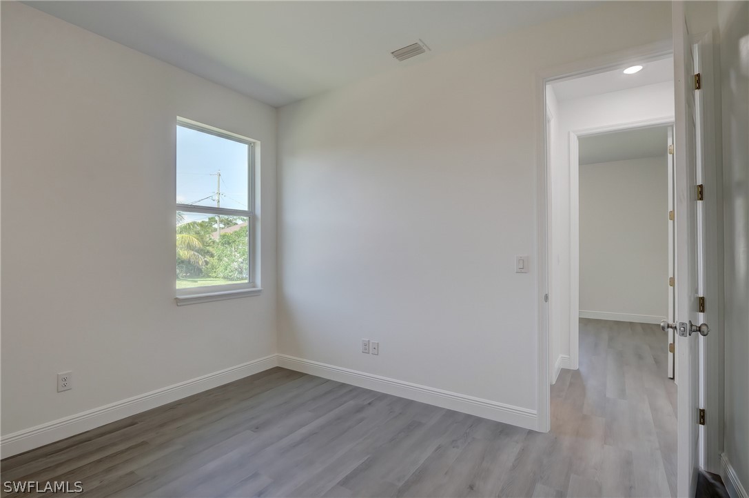 18457 Lee Road Fort Myers, FL 33967 - Photo 20 of 28 an empty room with wooden floor and windows