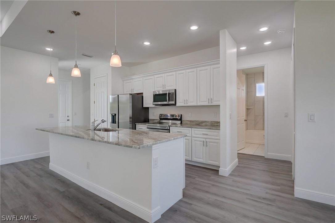 18457 Lee Road Fort Myers, FL 33967 - Photo 10 of 28 a kitchen with kitchen island white cabinets and stainless steel appliances
