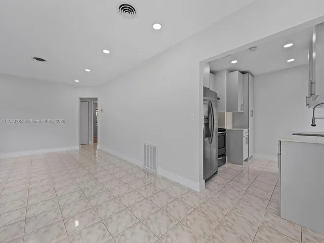 a view of a kitchen with a refrigerator and a sink