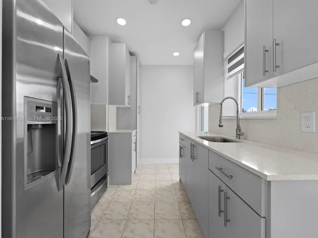 a kitchen with stainless steel appliances a refrigerator sink and cabinets