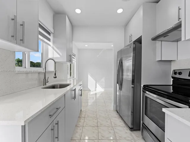 a kitchen with a sink appliances and cabinets