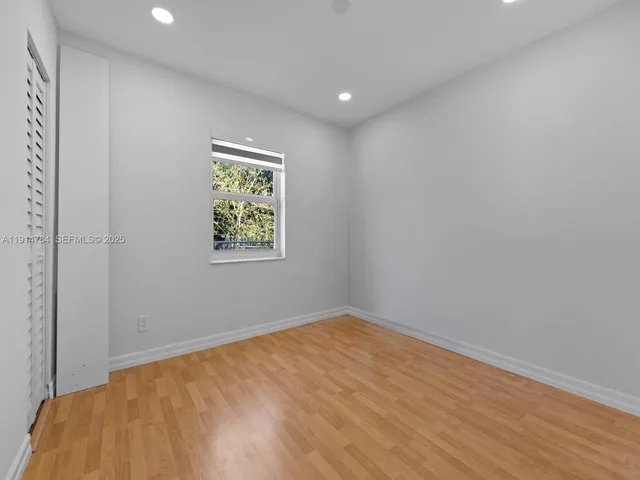 a view of room with window and wooden floor