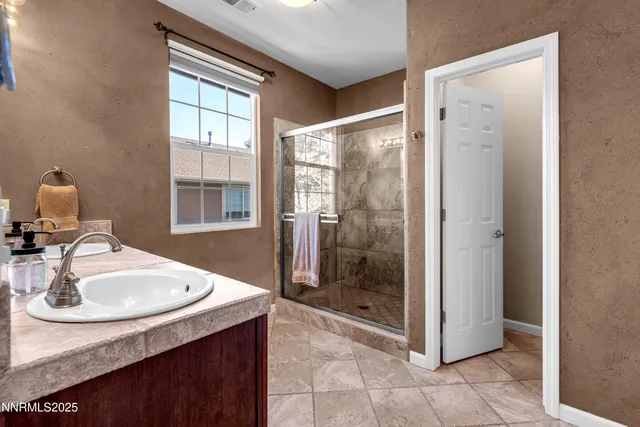 a bathroom with a sink shower and a mirror