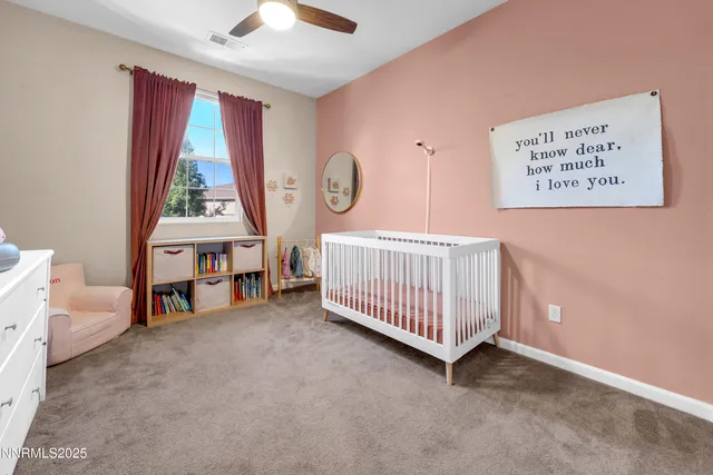 a view of a room with baby crib and a window