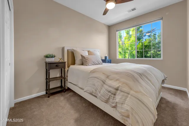 a large bed sitting in a bedroom next to a window