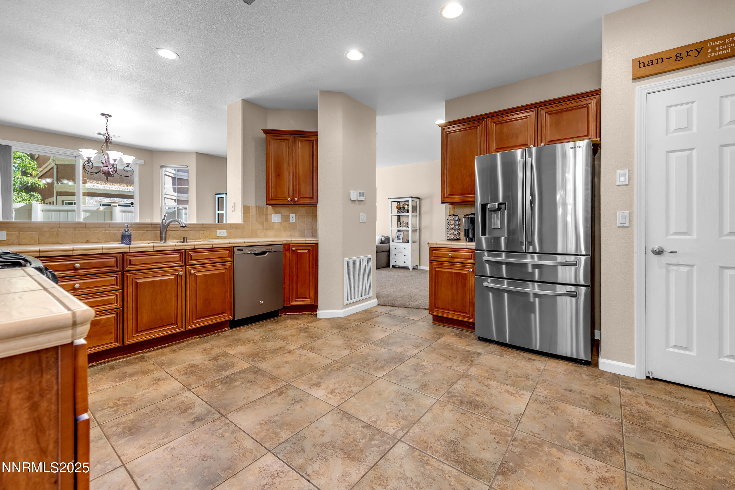 1811 Stetson Drive Reno, NV 89521 - Photo 9 of 34 a kitchen with stainless steel appliances granite countertop a refrigerator and a sink