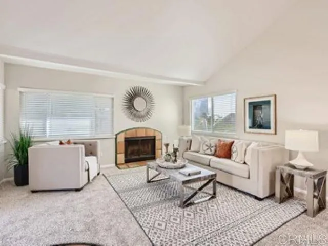 a living room with furniture a rug and a large window