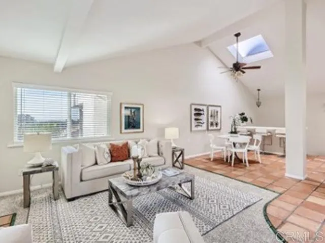 a living room with furniture a rug and a large window