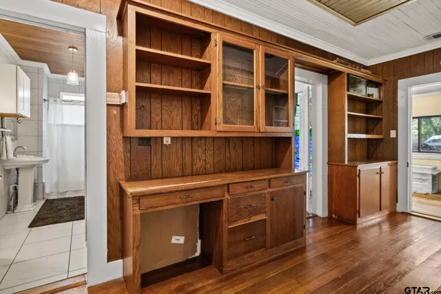 a view of an empty room with wooden floor and a cabinet