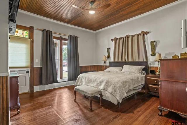 a bedroom with a bed and a large mirror on the dresser