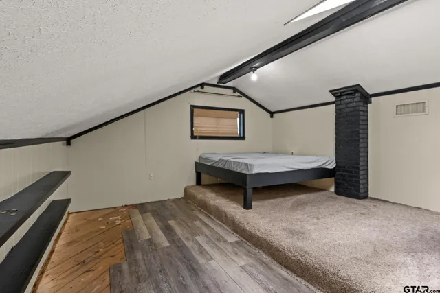 a bedroom with a bed and a wall painting