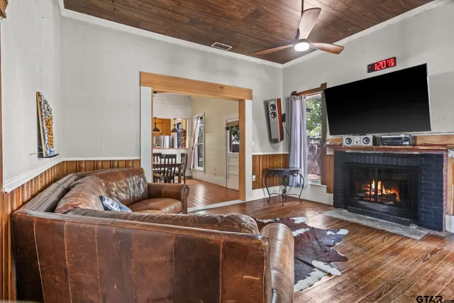 a living room with furniture a flat screen tv and a fireplace