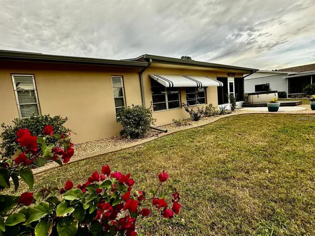 a view of a house with backyard and sitting area