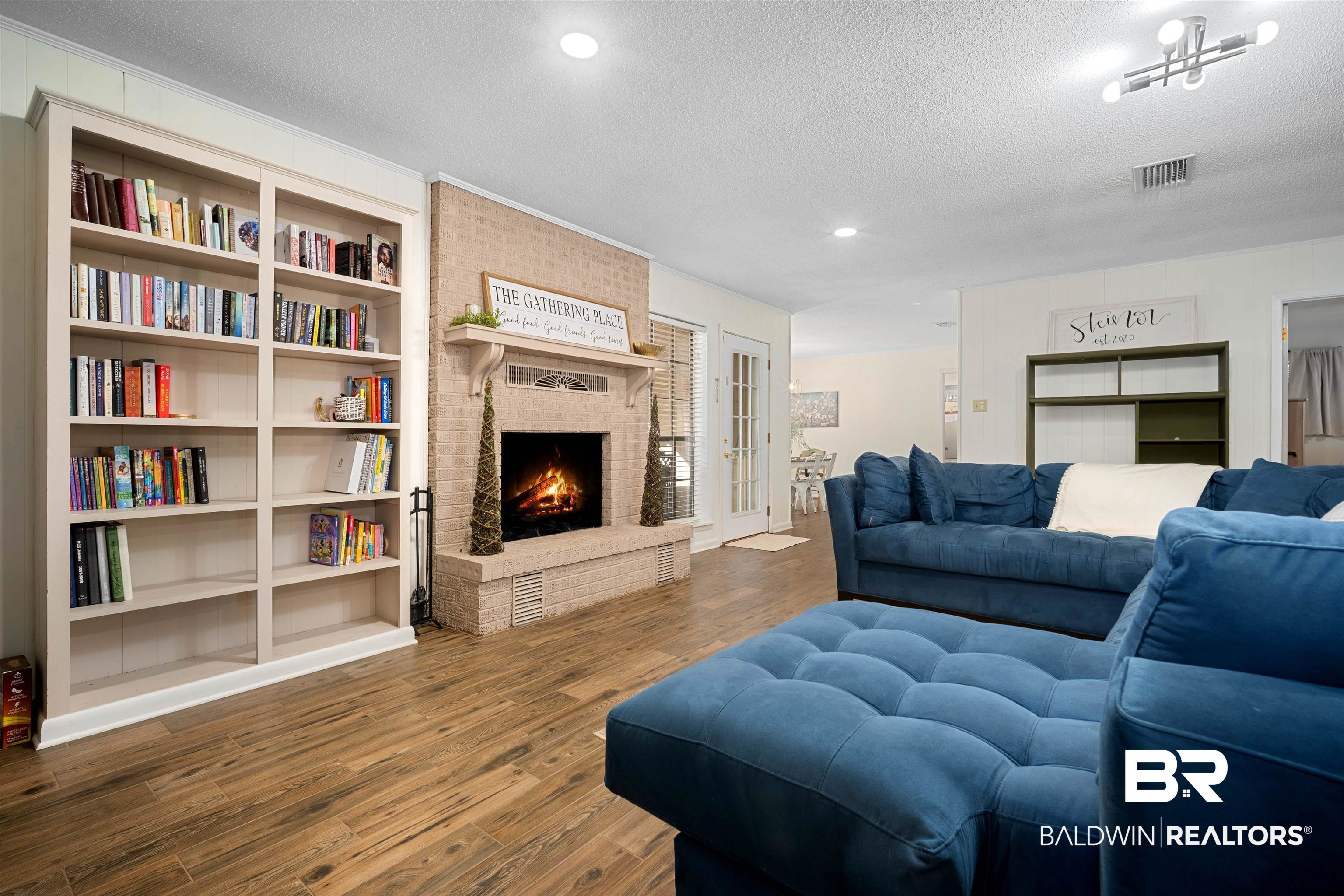 74 Caisson Trace Spanish Fort, AL 36527 - Photo 4 of 26 Living room with a textured ceiling, wood finished floors, a brick fireplace, recessed lighting, and built in features