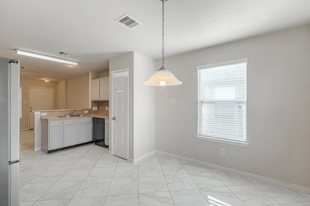 a large kitchen with granite countertop a stove a sink a window and stainless steel appliances