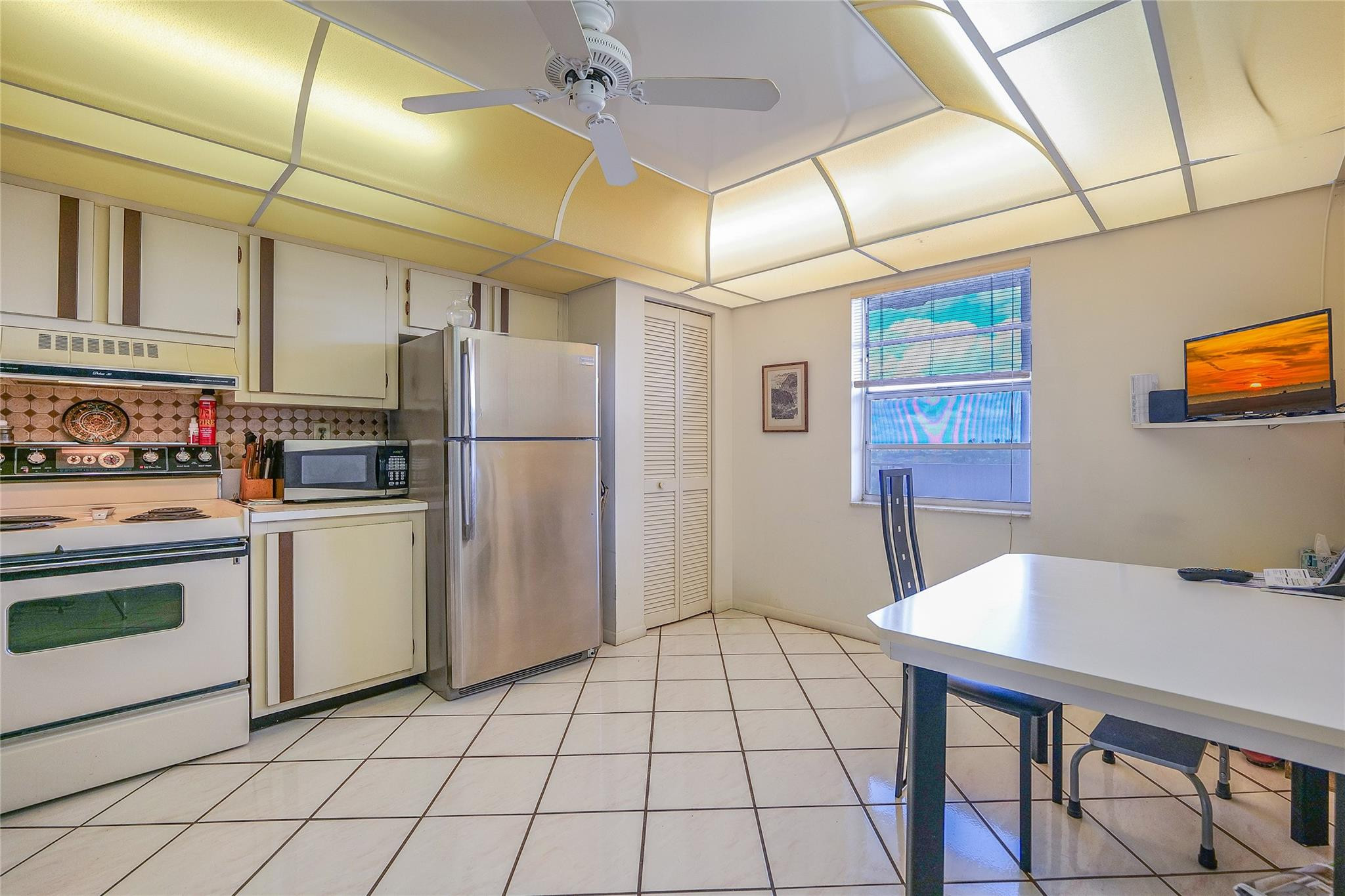 3910 Inverrary Boulevard, Unit 805B Lauderhill, FL 33319 - Photo 10 of 51 a kitchen with a table chairs refrigerator and cabinets