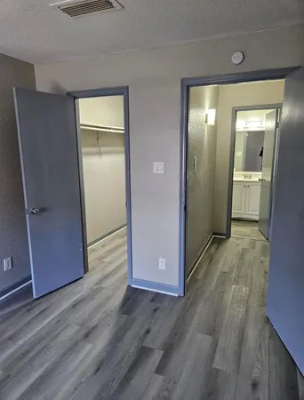 an empty room with wooden floor and closet