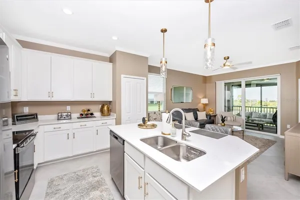 a open dining room with stainless steel appliances kitchen island granite countertop a sink a stove and a refrigerator