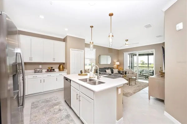 a living room with furniture kitchen view and a chandelier