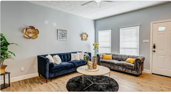 a living room with furniture and a wooden floor