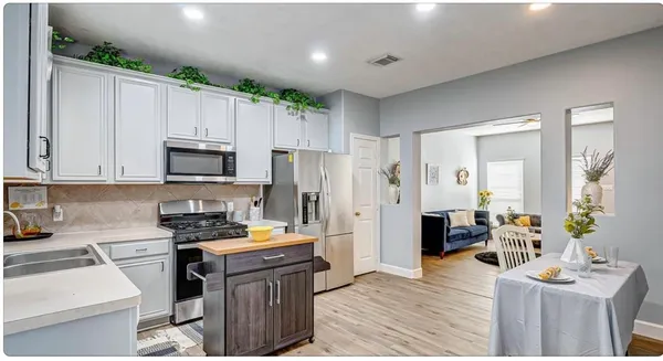 a kitchen with kitchen island granite countertop a stove refrigerator and microwave