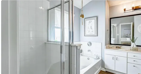 a bathroom with a bathtub sink and mirror with window