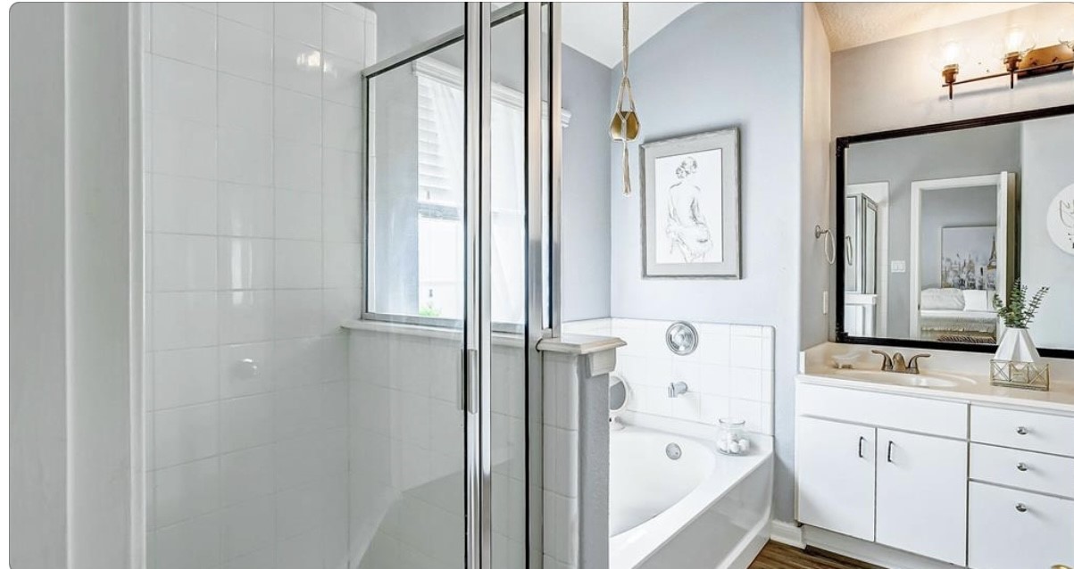 18927 Crescent Fountain Road Spring, TX 77388 - Photo 8 of 13 a bathroom with a bathtub sink and mirror with window