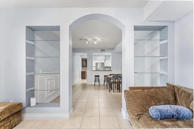 a living room with furniture and a dining table with kitchen view