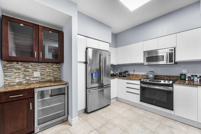 a kitchen with stainless steel appliances granite countertop a refrigerator stove and sink