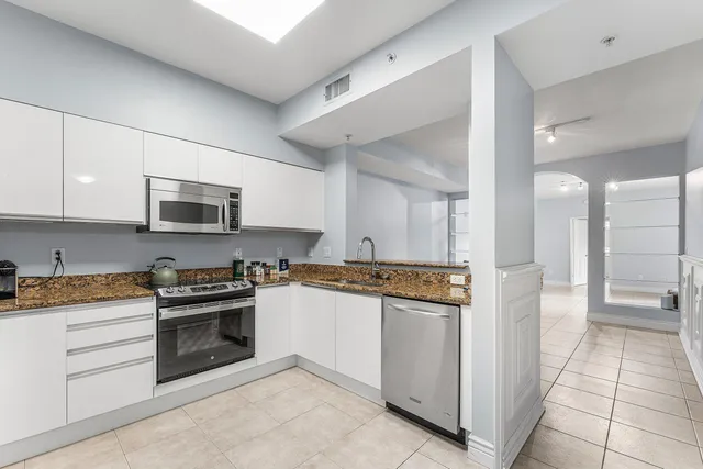 a kitchen with stainless steel appliances granite countertop a stove and a refrigerator